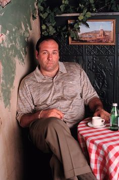 a man sitting at a table with a cup and saucer