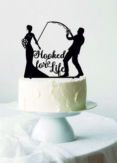 a wedding cake topper with a silhouette of a bride and groom holding a fishing rod