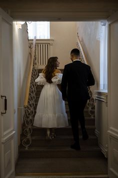 a bride and groom are walking down the stairs