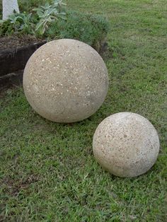 two large rocks sitting in the grass next to each other