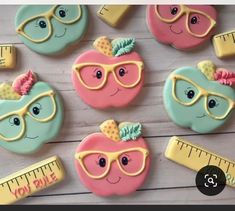 decorated cookies are arranged in the shape of an apple, ruler and eyeglasses