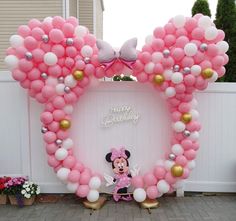 a minnie mouse balloon arch is decorated with pink and white balloons