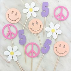 peace signs and flowers are on sticks in the shape of smiley faces with daisies