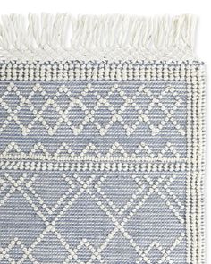 a blue and white rug with fringes