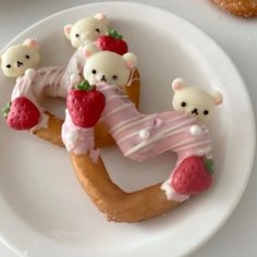 there are some cookies shaped to look like bears on a plate with strawberries in the shape of numbers