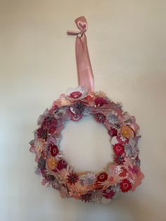 a pink wreath hanging on the wall