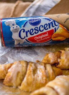 croissants wrapped in wax paper next to a carton of crescent rolls