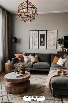 a living room with gray couches and pictures on the wall above them, along with a round coffee table