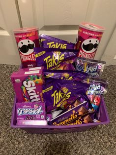 a purple basket filled with lots of different types of candy