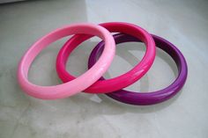 Early 1950s German set of three Handmade Boho Lucite Bracelets, in shades of pink Bangles width 1 cm/0,39in. It can be used alone but it produces an even better effect when blended with more other same or different colors; we happy to provide you this. Made in Germany Measurements: inner diameter: 6,5 cm/2.5in external diameter: 8,1cm / 3.2in Weigh total 43,7 grams. Shop Policies/FAQ: https://www.etsy.com/your/shops/VintageBeadsLisbon/policies (Payment, Refund, Shipping Policy & Additional I Adjustable Stackable Pink Bangle, Handmade Adjustable Pink Bangle, Adjustable Handmade Pink Bangle, Handmade Pink Bohemian Bangle, Handmade Bohemian Pink Bangle, Pink Plastic Bangle Jewelry, Bohemian Purple Bangle, Vintage Bakelite Bangle, 60s Jewelry