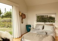 a bed sitting in a bedroom next to a sliding glass door that leads out onto a lush green field