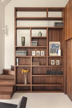 a bookshelf filled with lots of books next to stairs