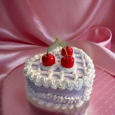 a heart shaped cake with two cherries on top