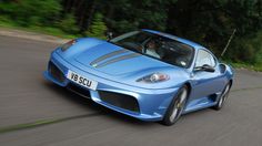 a blue sports car driving down the road