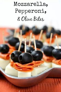 black olives and cheese bites are arranged on a platter with toothpicks