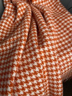 an orange and white blanket sitting on top of a bed