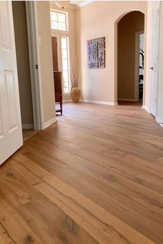 an empty living room with hard wood floors and white trim on the door way to another room