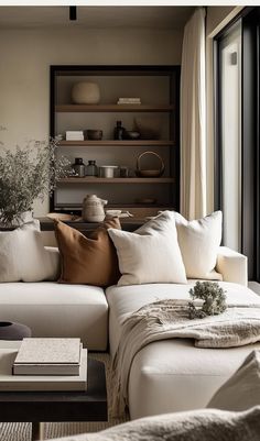 a living room filled with lots of white furniture and pillows on top of a couch