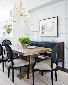 a dining room table with four chairs and a potted plant in the center on top