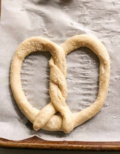 two pretzels shaped into the shape of a heart on top of wax paper