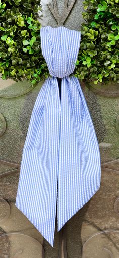 a blue and white striped bow tie hanging from the side of a stone planter