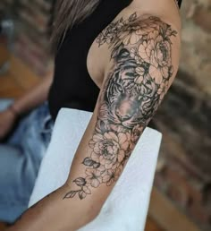 a woman with a tiger and flowers tattoo on her arm