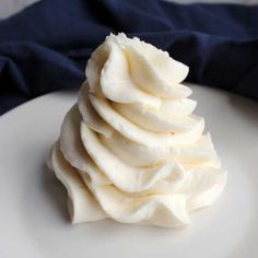 a white plate topped with whipped cream on top of a blue cloth covered tablecloth