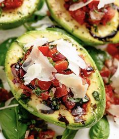 stuffed avocados with tomatoes, mozzarella and parmesan cheese on top