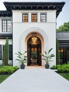 a large white house with an entrance way leading into the front yard and dining area