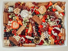 an assortment of cheeses, crackers, and other snacks in a white box