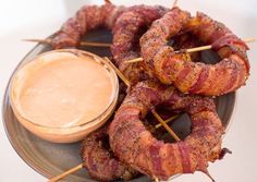 bacon skewers with dipping sauce on a plate