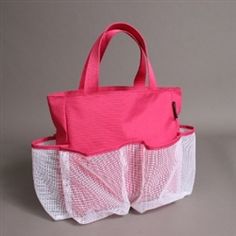 a pink and white handbag with mesh on the bottom, sitting in front of a gray background