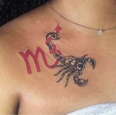 a woman with a scorpion tattoo on her chest and the letter m in red ink