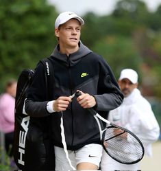 a man holding a tennis racquet on top of a tennis ball racket