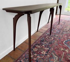 a long wooden table sitting on top of a rug