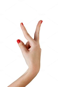 a woman's hand with red nail polish holding up the peace sign on white background