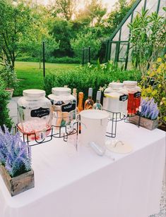 a table topped with lots of different types of ice buckets and containers filled with liquid