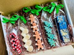 a box filled with candy and candies on top of a wooden table next to a green ribbon