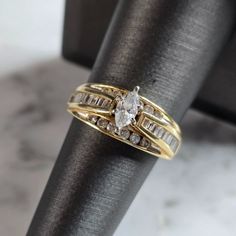 a gold ring with two rows of diamonds on it and a black napkin in the background