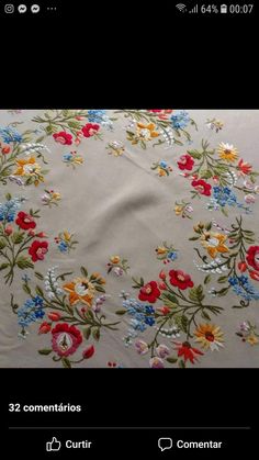 a white table cloth with colorful flowers and leaves on it, in the middle of a black background