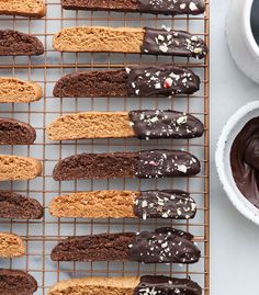 chocolate covered cookies on a cooling rack next to a cup of coffee