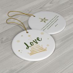 two white ceramic ornaments with gold lettering on the front and back of each ornament