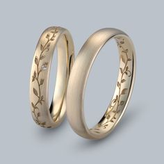 two gold wedding bands with leaves and diamonds on the inside, set in 18k yellow gold