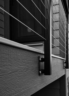 a black and white photo of the outside of a house with shutters on both sides