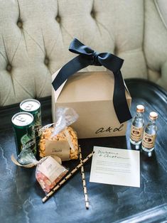 an open box sitting on top of a table next to two bottles and some candy