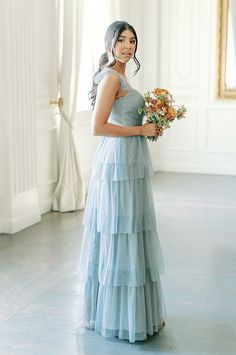 a woman in a blue dress holding flowers