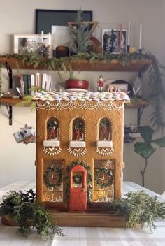 a gingerbread house decorated with greenery and decorations