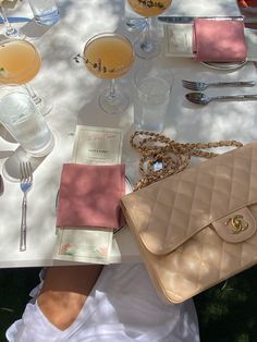 a woman sitting at a table holding a purse