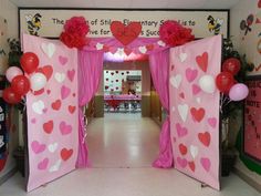 an entrance to a school decorated for valentine's day with pink and red decorations