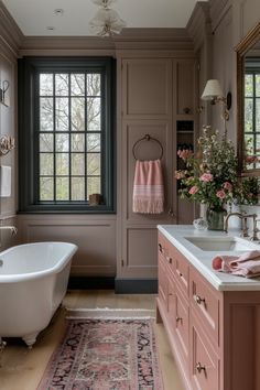 a bath room with a tub a sink and a rug on the floor in front of a window